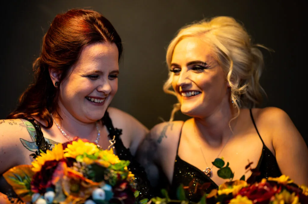Chelsea and Erin laughing together with their bouquets