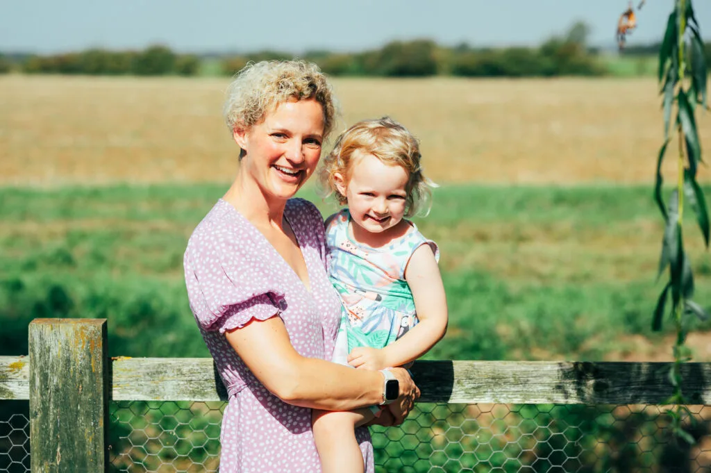 Mum holding her daughter in a field