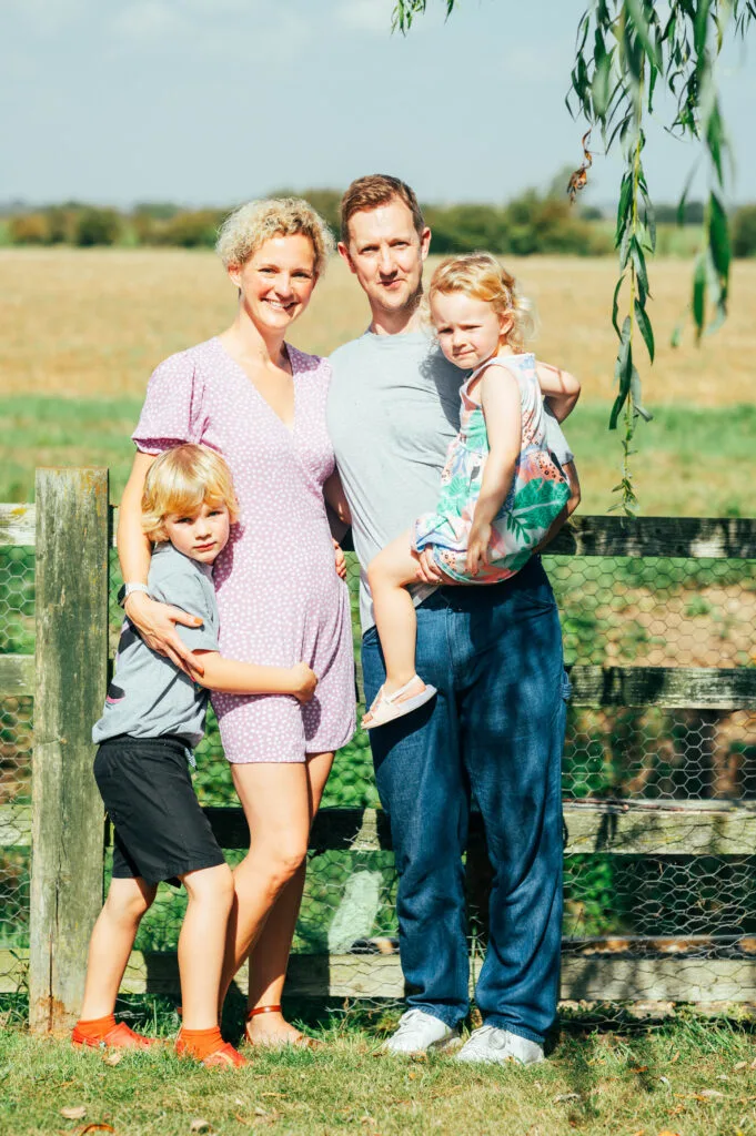 Family standing by a fence in a meadow