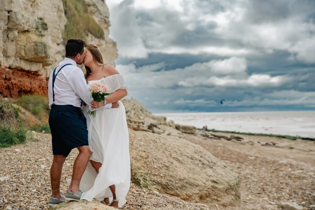Couple standing on a pebble beach under a big sky
