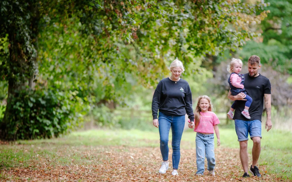 Family walking through a park in autumn