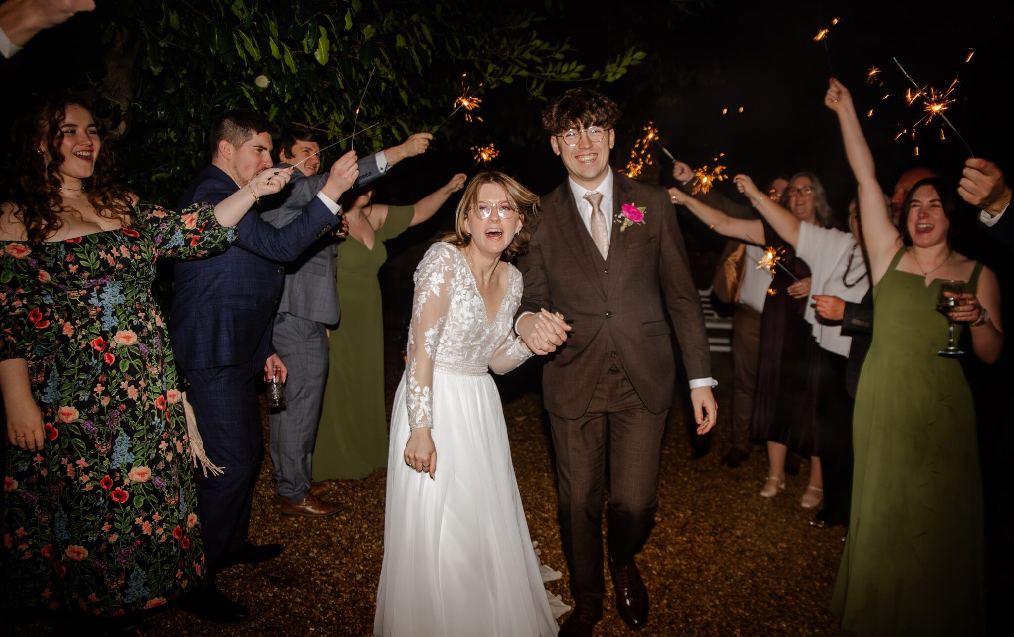 Couple walking through a sparkler send-off at night
