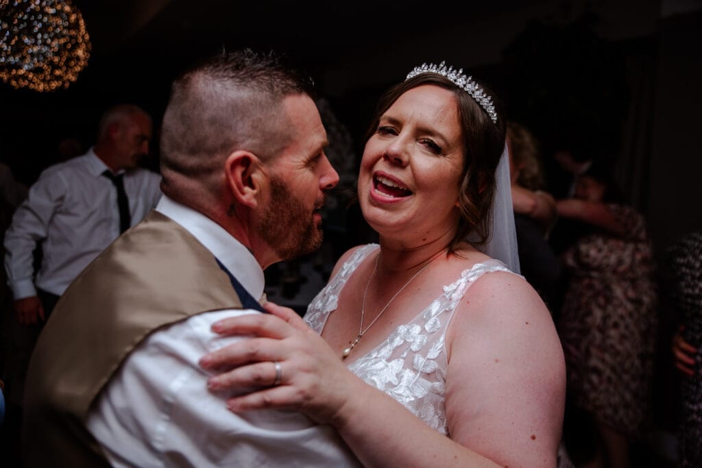 Couple sharing their first dance under festoon lights