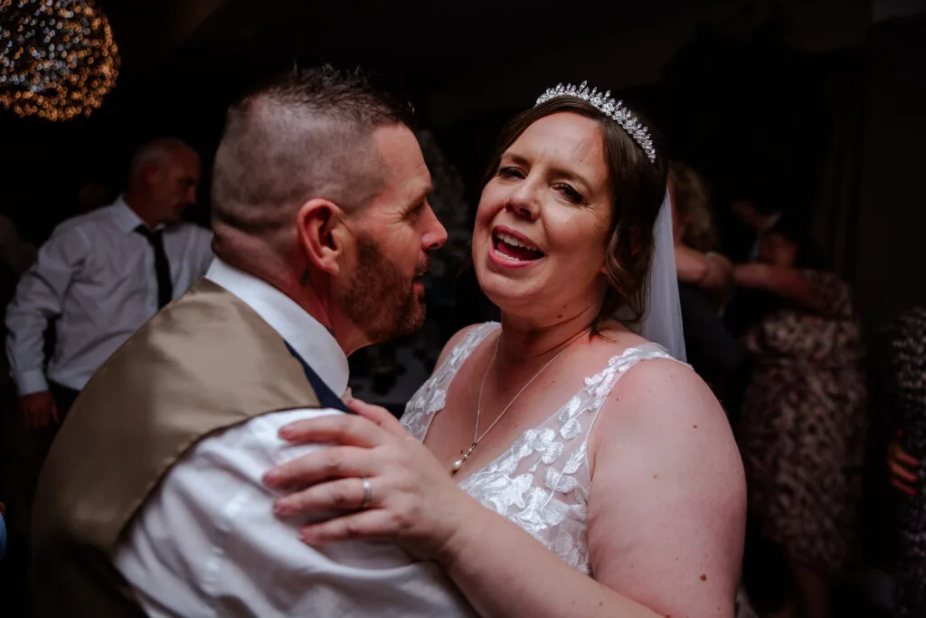 Couple sharing their first dance under festoon lights