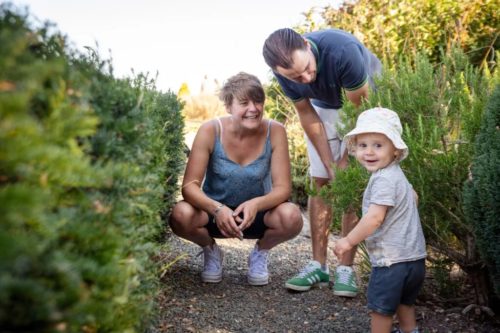 Parents crouching down to explore with their toddler