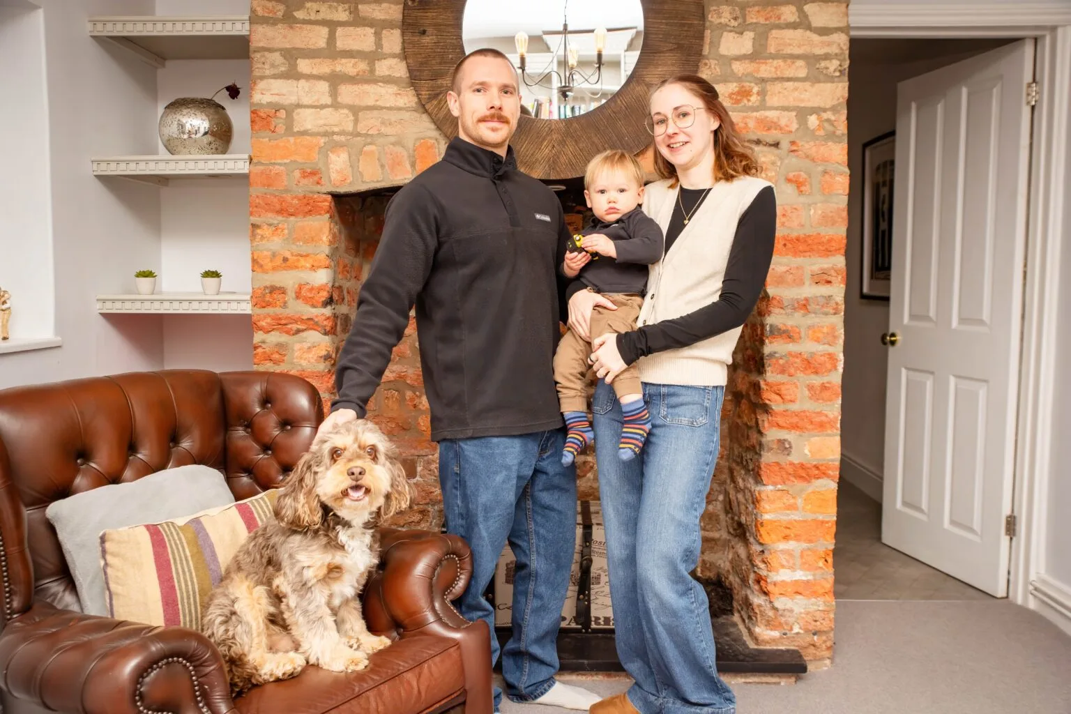 Family at home with their dog by the fireplace