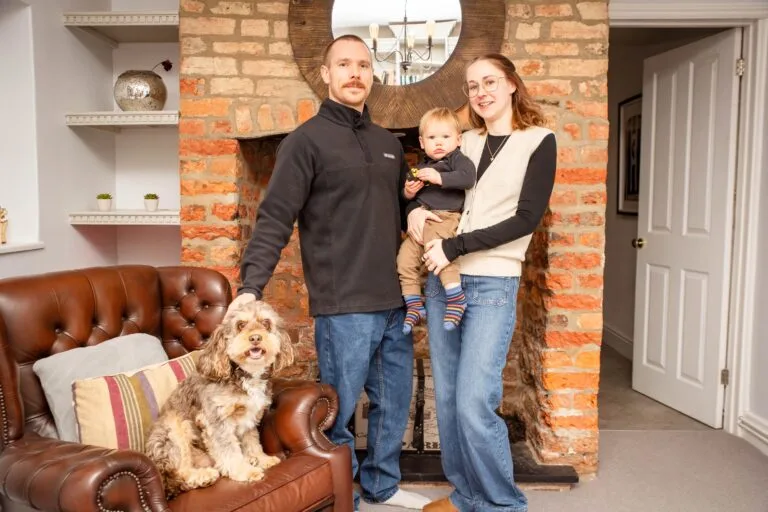 Family at home with their dog by the fireplace