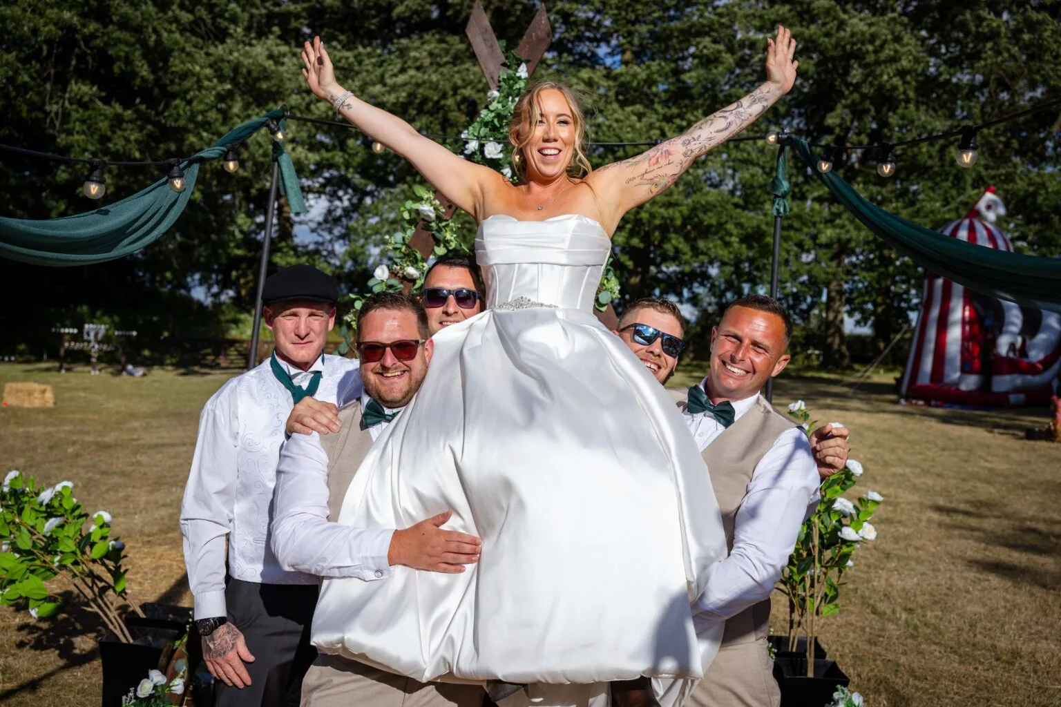 Bride throwing her arms up in celebration with the wedding party
